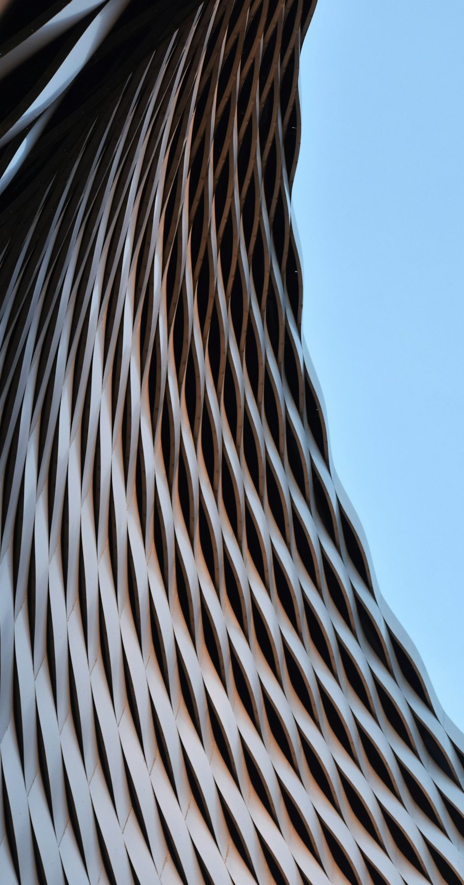 Más de contacto Estructura arquitectónica con patrones en espiral y fondo azul claro.